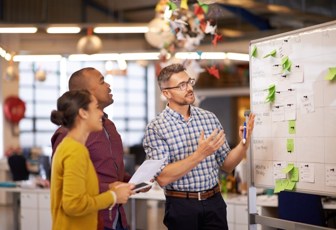 Whiteboard, manager plan and business people with strategy and speaking in a office.