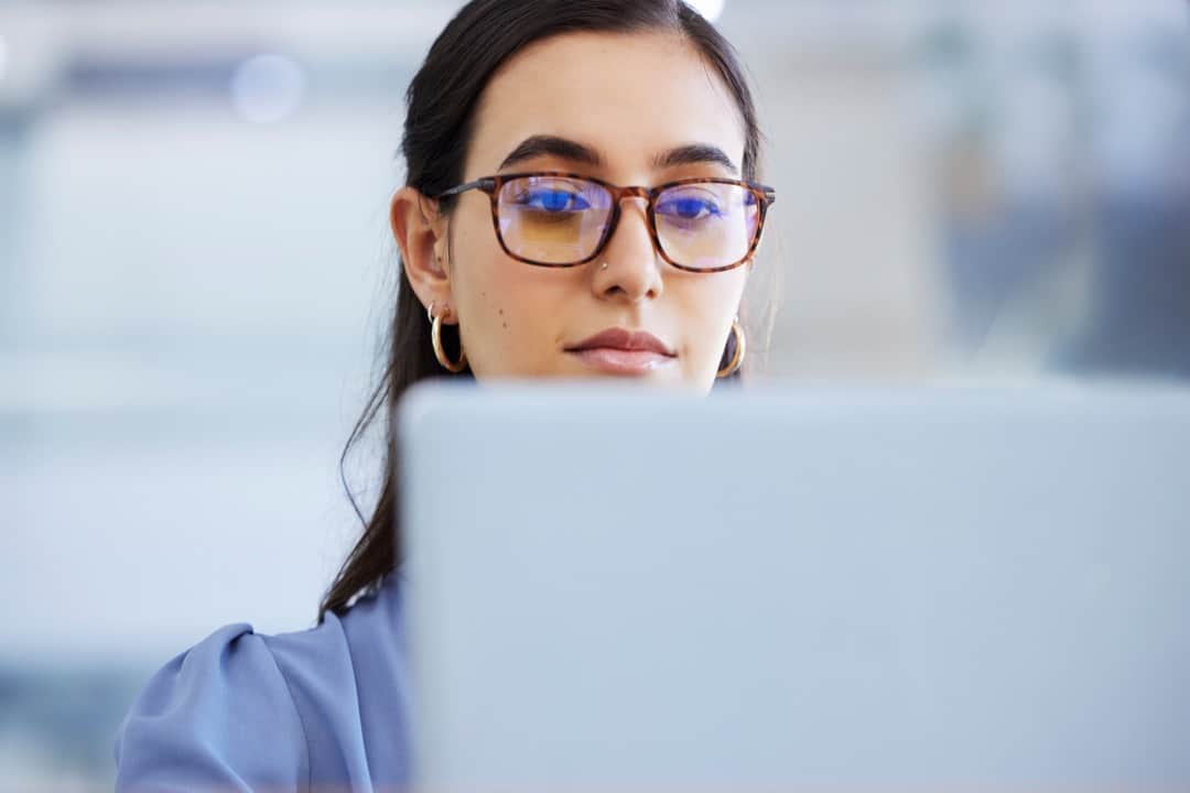 glasses and working on laptop in office